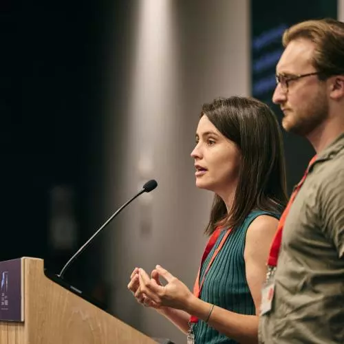 Two young people address an audience from a lectern