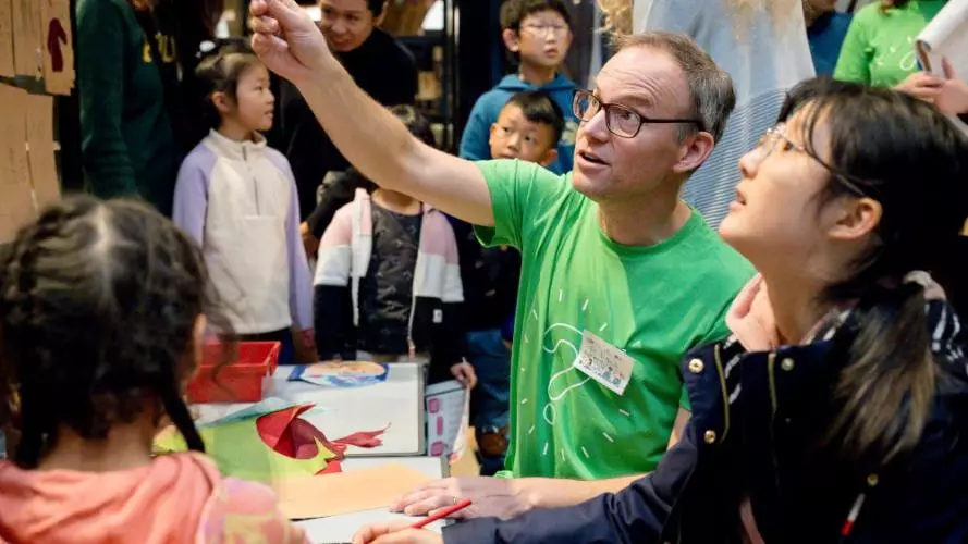 Researcher showing lady an object in museum cabinet