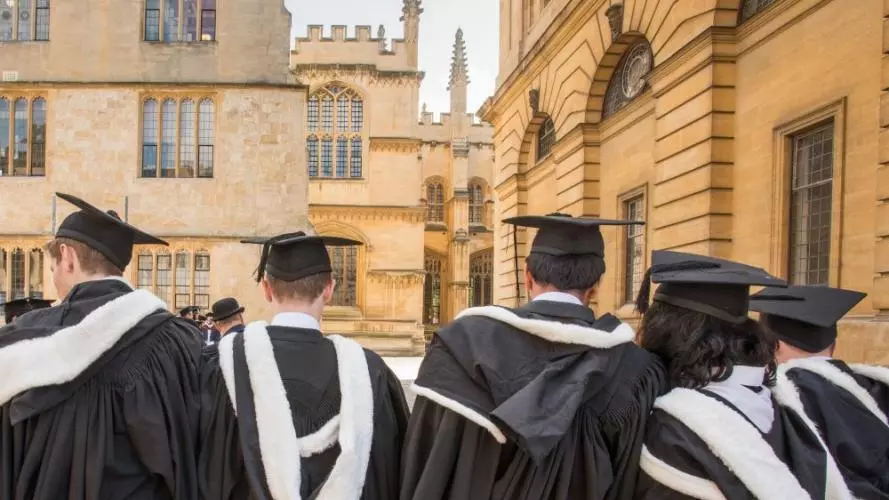 Students wearing gowns and mortar boards outside the Sheldonian