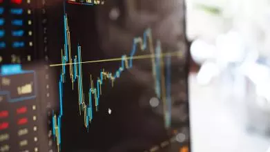 A computer monitor showing a graph plotting three lines of data, with various spikes and downturns