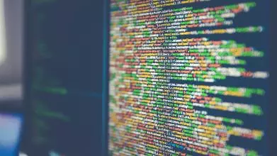 Pages of mmulti-coloured code across two computer screens