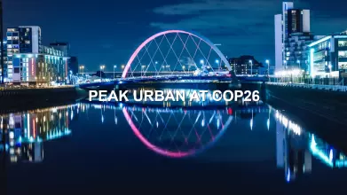 The title PEAK Urban at COP26 superimposed on a city scape at night