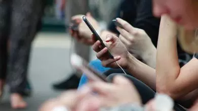 A group of people scrolling through their devices