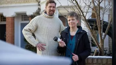 Dr Phil Grünewald and Dr Tina Fawcett hold an electric vehicle charging cable 