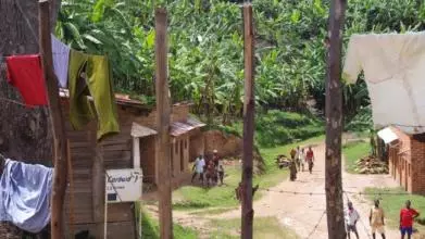 Village in Burundi with wooden houses, trees and washing hanging out