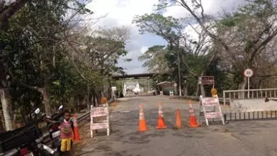 A closed road in Columbia, with a young boy standing at the side