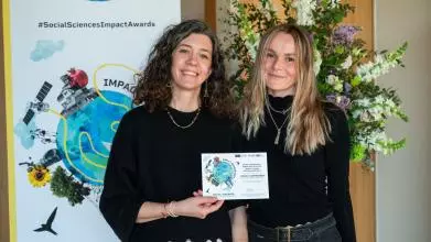 Dr Andriani Fili and colleague smile while holding their 2025 Social Sciences Impact Award 