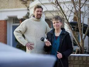 Dr Phil Grünewald and Dr Tina Fawcett hold an electric vehicle charging cable 