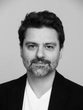 Black & white photo of white man with short dark hair and black jacket