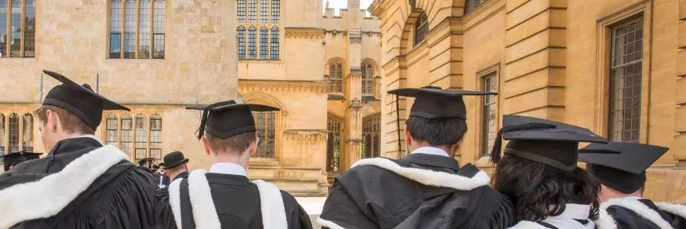 Students wearing gowns and mortar boards outside the Sheldonian
