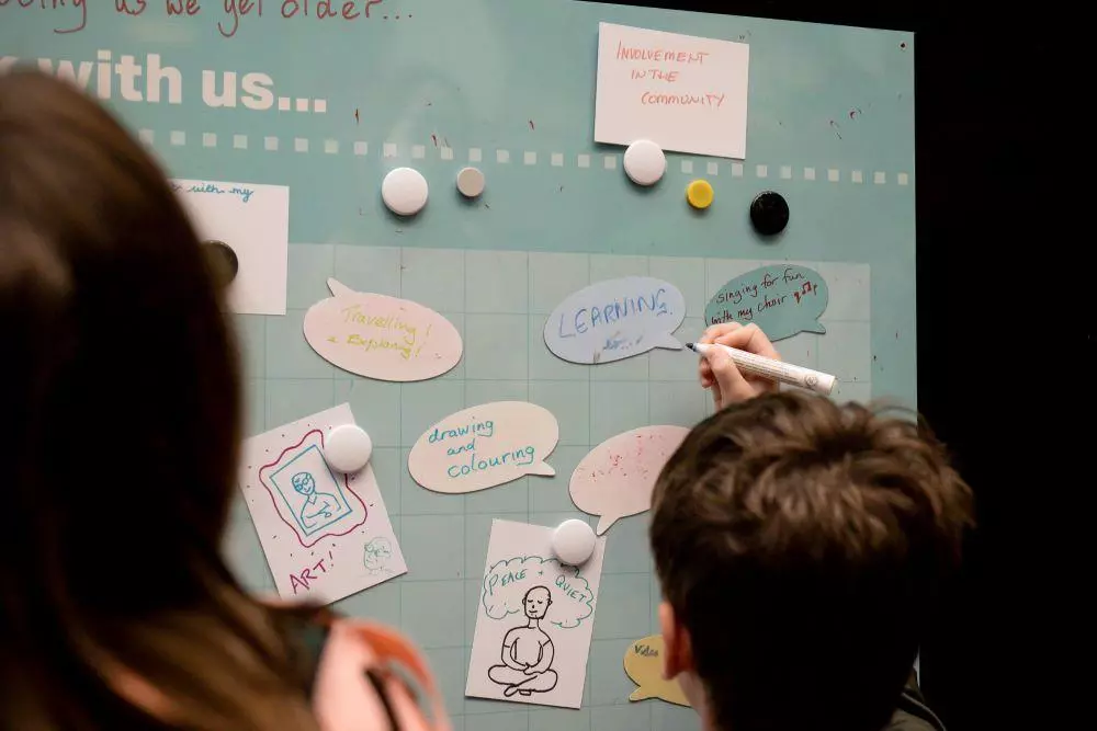 Children writing on post it notes on disaply board